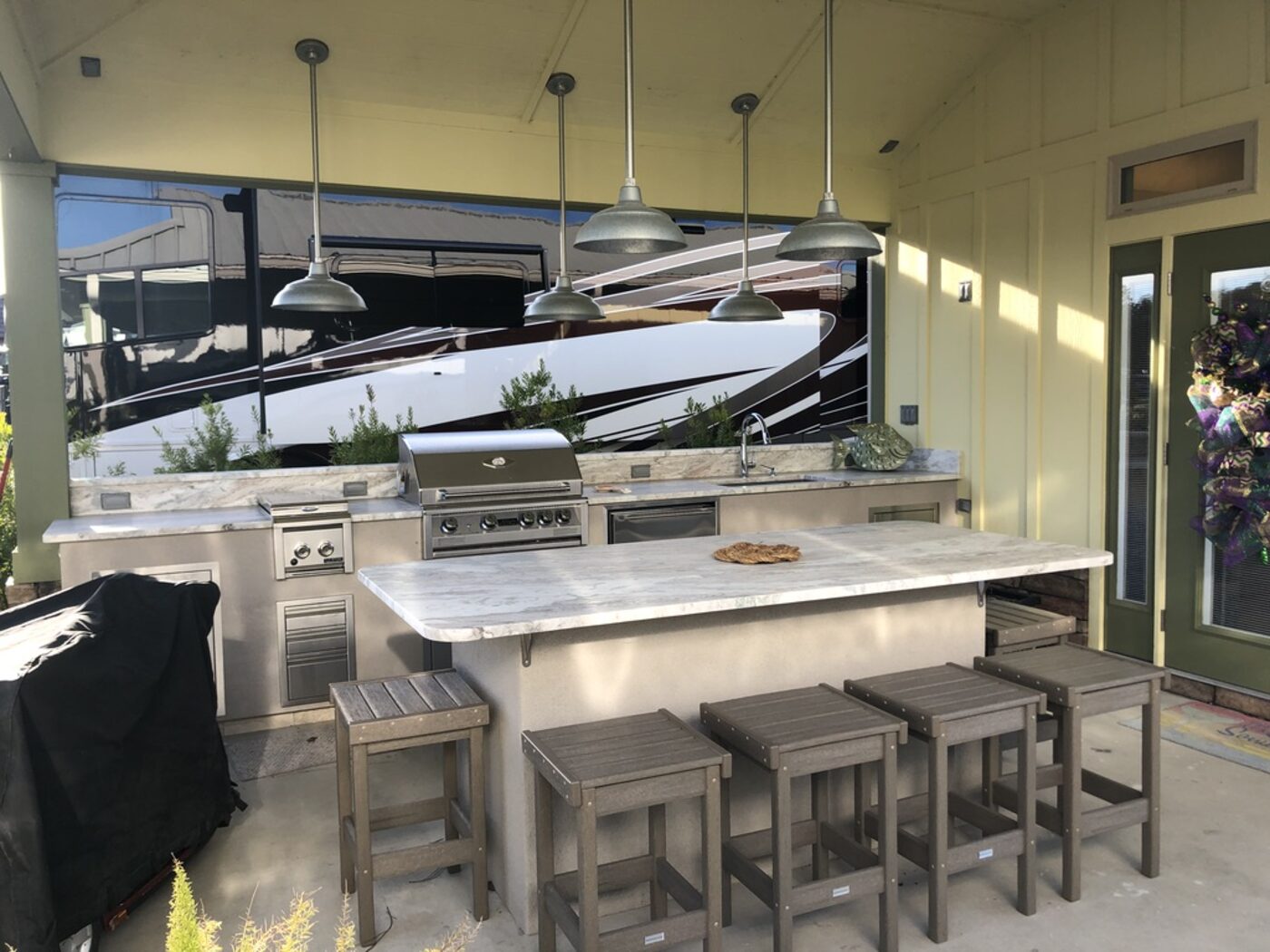 Outdoor kitchen bar in stone with bar seating