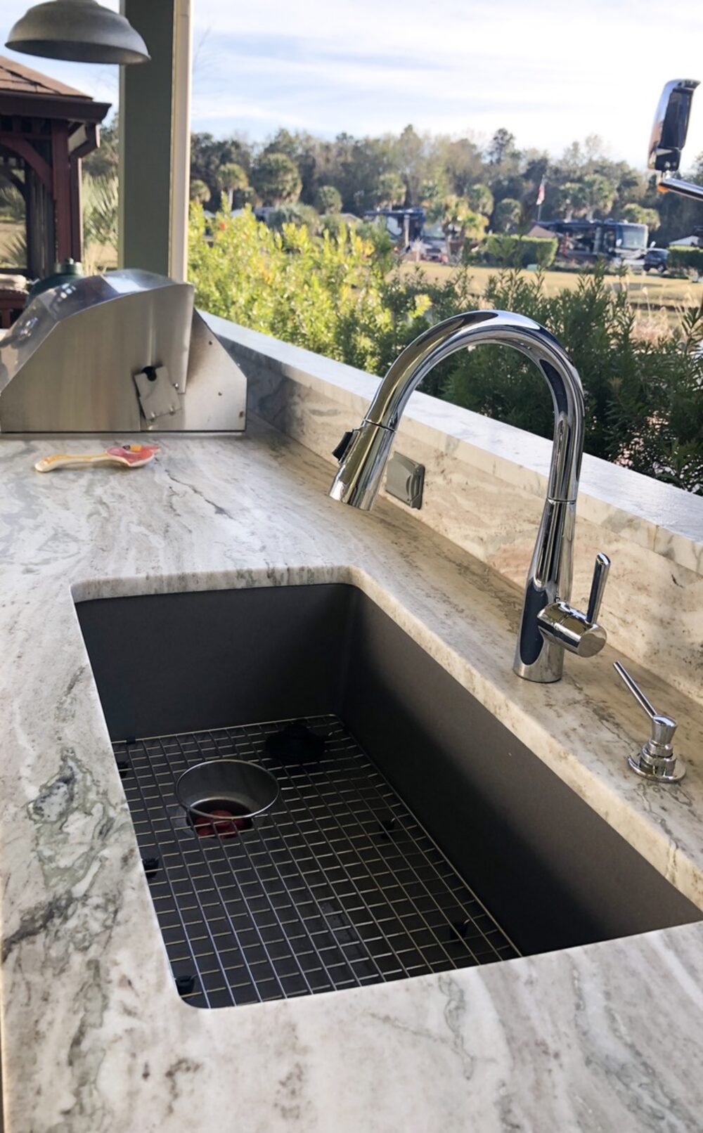 Single bowl sink cut into the stone of an outdoor counter